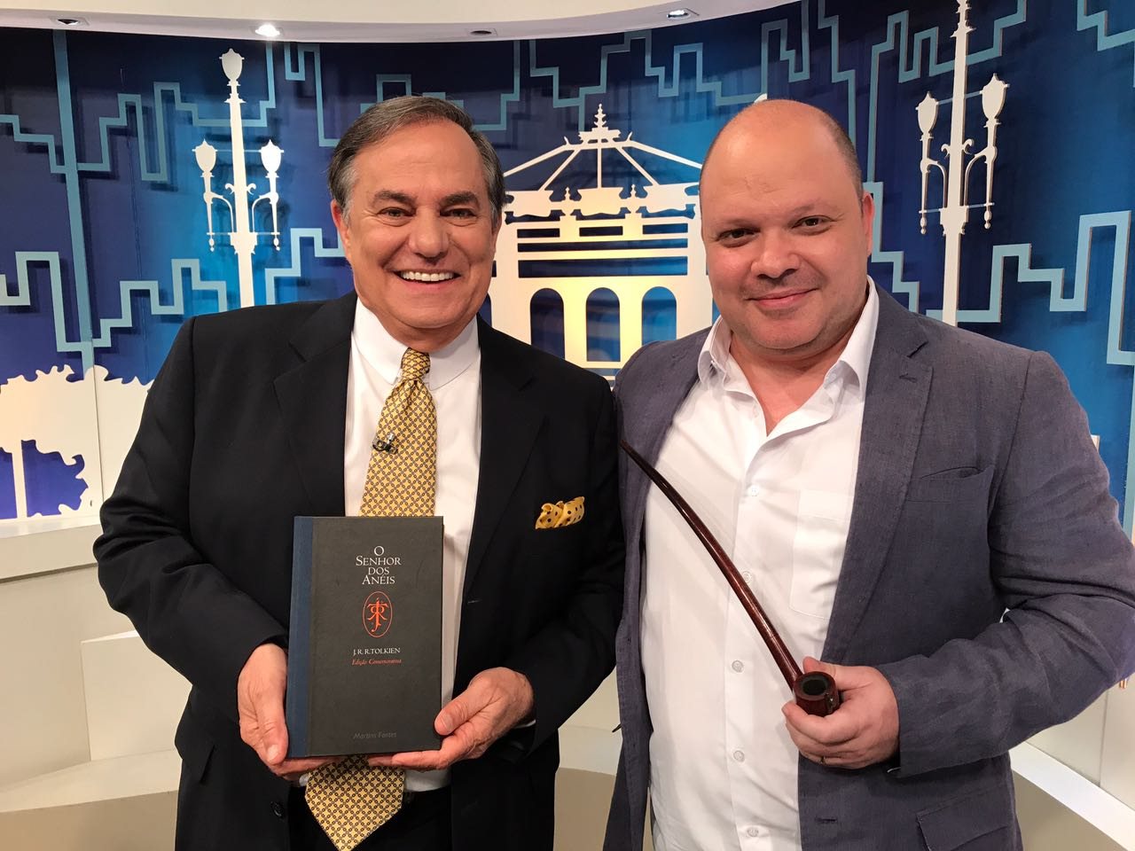 Daniel Cossi no programa Todo Seu, da TV Gazeta, com um cachimbo e a edição comemorativa de O Senhor dos Anéis